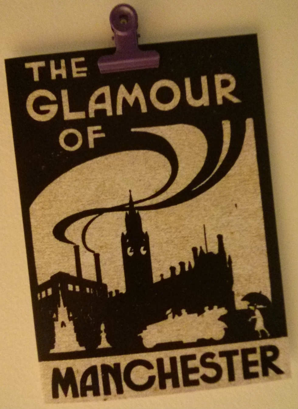 An art deco monochrome postcard that says 'The glamour of Manchester'